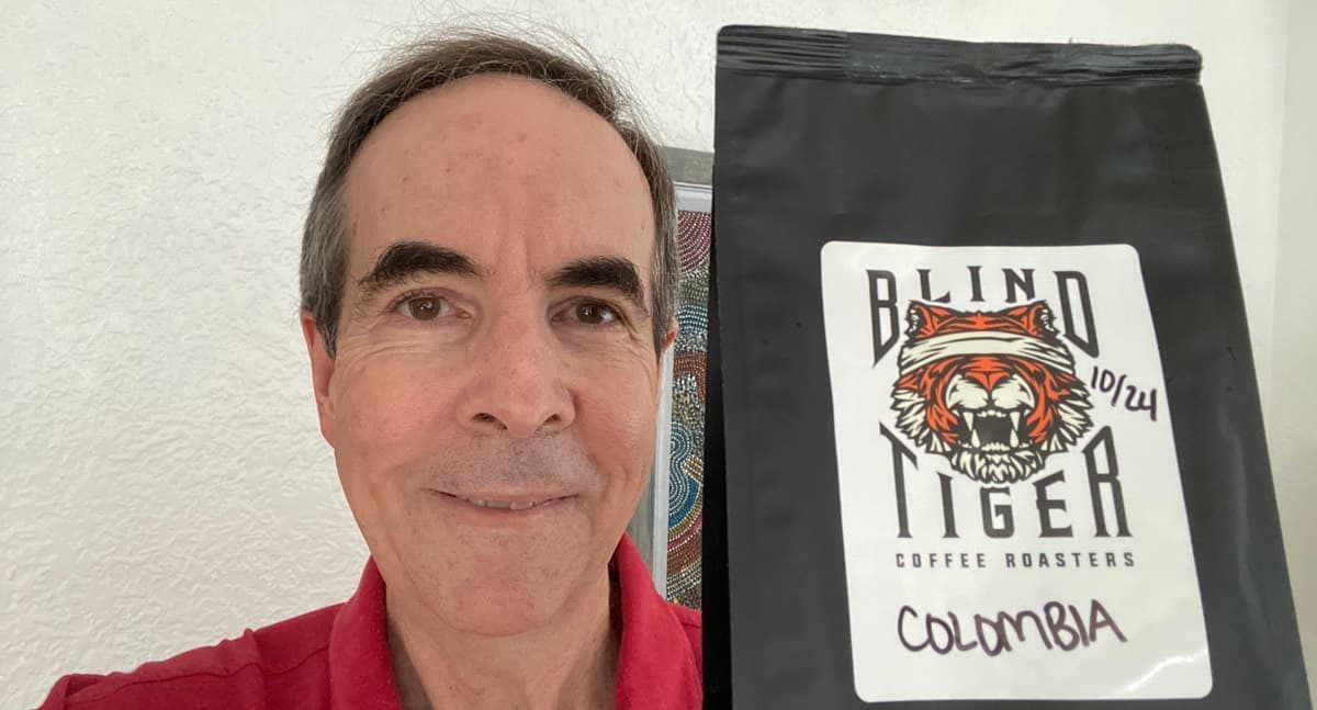 John holding a bag of coffee beans